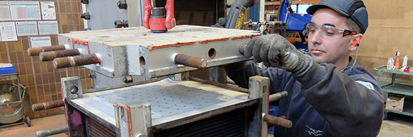 Man working on heat exchanger in workshop